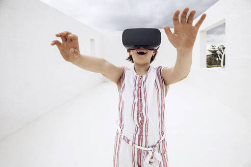 Little girl discovering empty space with VR goggles - MCF00515