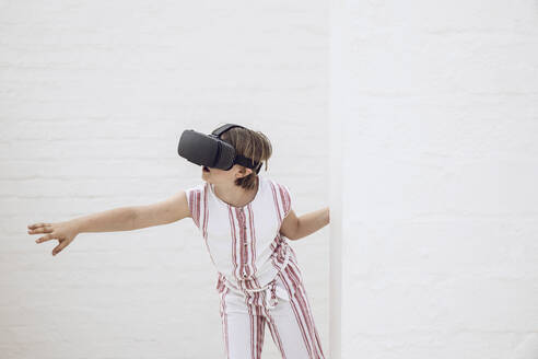 Little girl discovering empty space with VR goggles - MCF00517