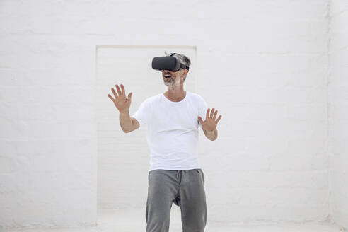 Ein erwachsener Mann entdeckt den leeren Raum mit einer VR-Brille - MCF00519