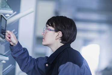 Female technician operating a machine - SGF02465