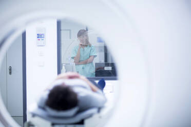 Patientin im Krankenhaus während einer CT-Untersuchung, Radiologin - SGF02471