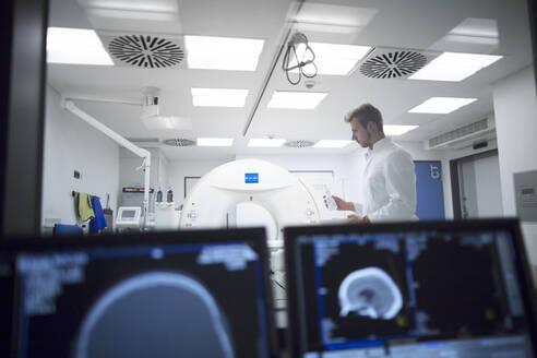 Radiologe an einem Röntgengerät in einem Krankenhaus - SGF02475