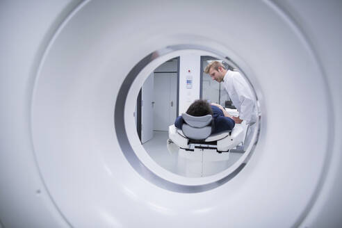 Patient im Krankenhaus während einer CT-Untersuchung und Radiologe - SGF02476