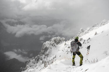 Mountaineer looking at distance, Italian Alps, Lecco, Lombardy, Italy - MCVF00109