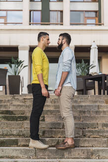 Homosexuelles Paar auf der Treppe stehend von Angesicht zu Angesicht - AFVF04331