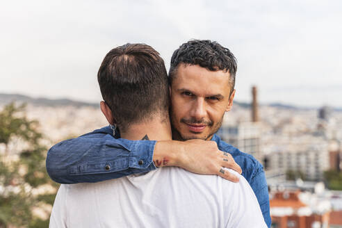 Porträt eines Mannes, der seinen Freund umarmt, Barcelona, Spanien - AFVF04336