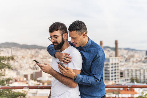 Schwules Paar telefoniert im Freien, Barcelona, Spanien, lizenzfreies Stockfoto