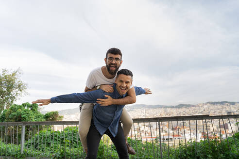 Porträt eines glücklichen schwulen Paares, das sich auf einer Aussichtsterrasse amüsiert, Barcelona, Spanien - AFVF04344