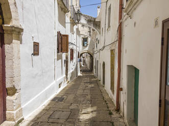 Italy, Province of Brindisi, Ostuni, Empty alley between old white-colored city houses - AMF07574