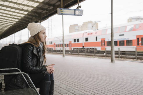 Junge Frau mit Rucksack wartet auf dem Bahnsteig, Vilnius, Litauen - AHSF01597