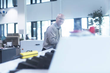 Manager bei der Arbeit in der Druckerei, Blick in die Kamera - SGF02491