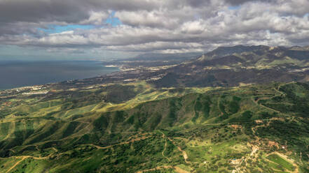 Luftaufnahme der wunderschönen Küste bunte Berge mit schweren Wolken vor einem Sturm in Marbella, Spanien - AAEF05692