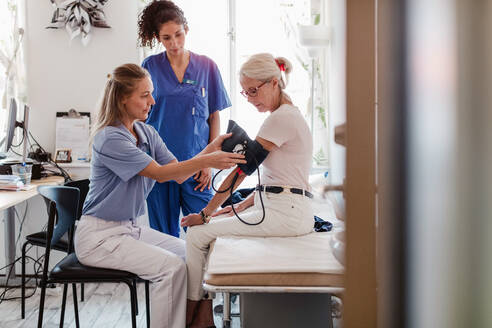 Ärztin kontrolliert den Blutdruck eines älteren Patienten im Krankenhaus - MASF14875