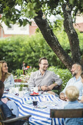 Freunde unterhalten sich am Esstisch bei einer Gartenparty an einem Sommerwochenende - MASF14940