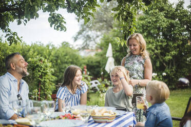 Familie amüsiert sich am Esstisch bei einer Gartenparty an einem Sommerwochenende - MASF14987