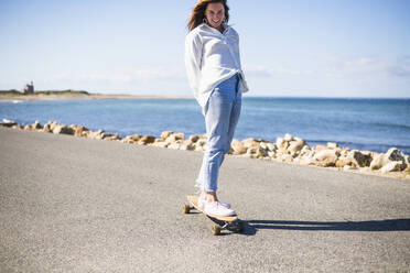 Junge Frau Longboard-Skateboarding auf Block Island - CAVF69429