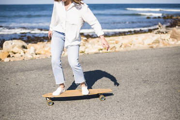 Junge Frau Longboard-Skateboarding auf Block Island - CAVF69430