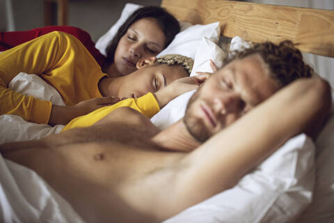 Drei Freunde schlafen zu Hause im Bett, lizenzfreies Stockfoto