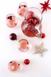 Preiselbeeren im Getränk mit Weihnachtsschmuck auf dem Tisch - CAVF69628
