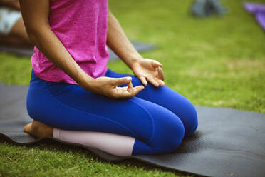 Low section of woman meditating in park - CAVF69656