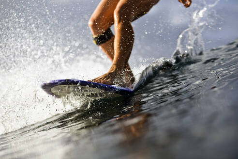 Tiefschnitt einer Frau beim Surfen im Meer - CAVF69678