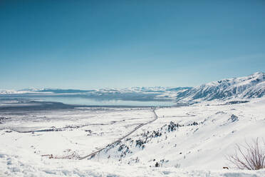 Blick auf eine schneebedeckte Landschaft vor blauem Himmel - CAVF69725