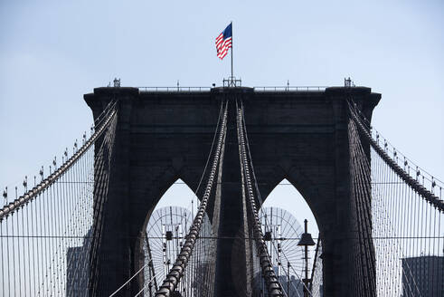 Niedriger Winkel Ansicht der amerikanischen Flagge auf Brooklyn-Brücke gegen klaren Himmel - CAVF69761