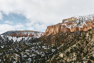 Niedriger Blickwinkel auf die Berge gegen den bewölkten Himmel im Bryce Canyon National Park im Winter - CAVF69803