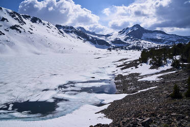 Landschaftlicher Blick auf einen zugefrorenen See am Berg gegen bewölkten Himmel - CAVF69804