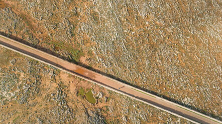 Aerial view of road crossing arid terrain at Balears Island, Spain. - AAEF05868