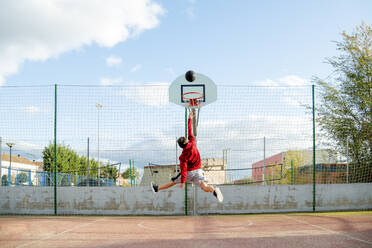 Jugendlicher, der Basketball spielt und eintaucht - CJMF00187