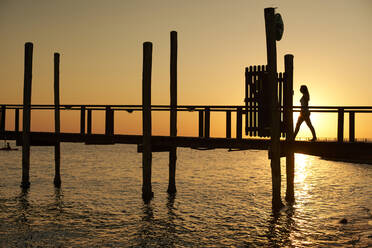 Silhouette of a woman walking on a bridge at sunset, Swakopmund, Namibia - VEGF01001