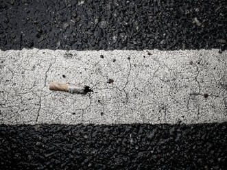 Cigarette but on road marking - JOHF04650