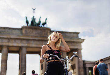 Jugendliches Mädchen mit Brandenburger Tor im Hintergrund, Berlin, Deutschland - JOHF04725