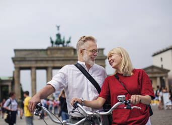 Happy couple together, Brandenburg Gate on background, Berlin, Germany - JOHF04728