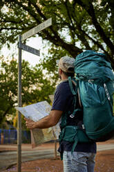 Backpacker checking the name of a street in his map - VEGF01011