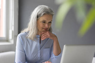 Portrait of mature businesswoman using laptop in office - MOEF02652