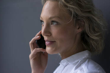 Portrait of smiling young businesswoman on the phone - MOEF02676