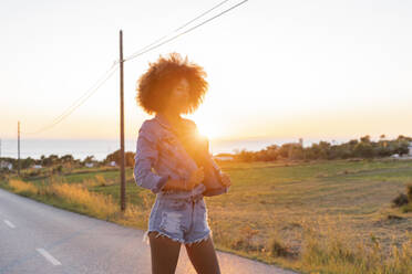 Young woman standing on street with closed eyes at sunset, Ibiza - AFVF04370