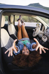 Junge Frau während einer Autofahrt, im Auto liegend - AFVF04385