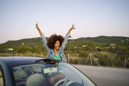 Young woman during road trip with raised arms - AFVF04389