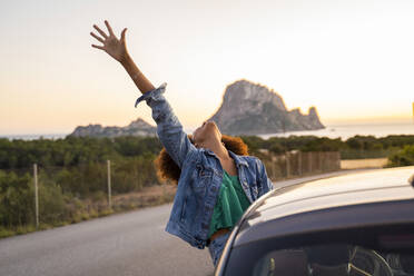 Young woman during road trip with raised arm - AFVF04394