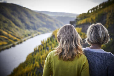 Zwei reife Frauen, die die Aussicht von einem Berg genießen - FMKF06048