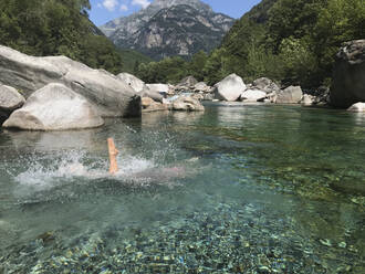 Woman's jump into refreshing mountain river water - GWF06329