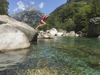 Sprung einer Frau ins erfrischende Wasser eines Bergflusses - GWF06331