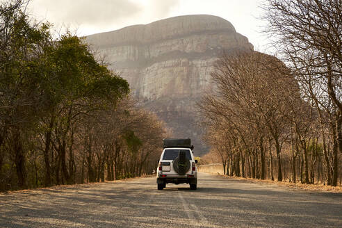 4x4 auf einer Landstraße mit einem Berg im Hintergrund, Limpopo, Südafrika - VEGF01072
