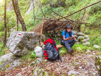 Älterer Mann, der eine Pause vom Wandern in einer Berglandschaft macht, Gröden, Trentino, Italien - LAF02450