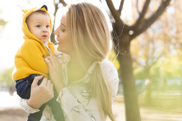 Mother carrying baby boy in a park - ERRF02263