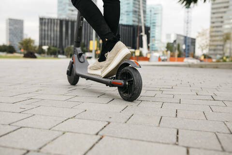 Young businesswoman with e-scooter in the city stock photo