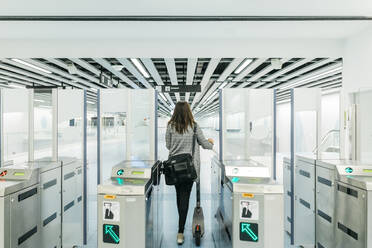 Young woman passing control in the subway with her electric scooter - JRFF03919